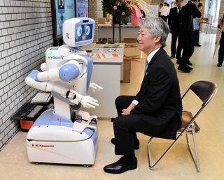 川崎重工業の自走式ロボット「ニョッキー」と会話をする橋本康彦社長