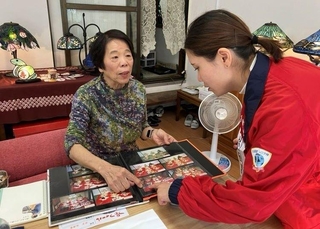 兵庫ヤクルト販売の「コミュニティナース」事業で、高齢者宅を訪れコミュニケーションをとる看護師（右）＝明石市内（同社提供）