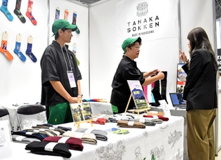 色鮮やかな靴下を並べた田中繊維のブース＝東京都江東区、東京ビッグサイト