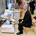 川崎重工業の自走式ロボット「ニョッキー」と会話をする橋本康彦社長