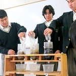 「森林」と「木がない山」、「岩山」に見立てた模型に水を注ぎ、水を蓄える機能を確かめる生徒ら＝神戸市北区大脇台