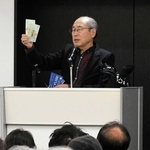 株主優待券を手に講演する桐谷広人さん＝神戸国際会館