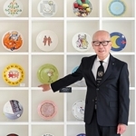 フェリシモ本社の商談スペースの一角に飾られたチャリティープレートの前に立つ矢崎和彦社長。プレートは同社の特色の一つの基金付き商品で、国連教育科学文化機関（ユネスコ）と約３０年にわたり共同実施する＝神戸市中央区新港町（撮影・大田将之）