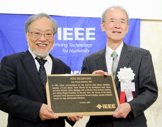 ＩＥＥＥの福田敏男２０２０年会長（左）から、マイルストーン賞の銘板を受け取る篠田傳さん＝１０月、明石市大明石町２
