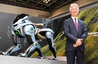 ４本脚で山道なども走れる未来のモビリティ「コルレオ」の模型と川崎重工業の橋本康彦社長＝東京都内