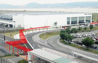 神戸空港の第１、第２ターミナルビルを結ぶ歩道。赤い図は設置される屋根をイメージしている（神戸市提供）