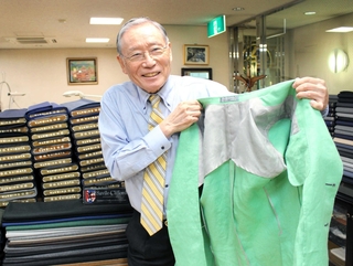 新作の超軽量ジャケットの内側を見せる柴田音吉さん＝神戸市中央区元町通４、柴田音吉洋服店