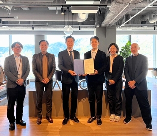 合意書を交わしたＵＤインパクトのキム・ジョンホン最高経営責任者（ＣＥＯ、中央右）と神戸新聞地域総研の稲川勉所長（同左）＝神戸市中央区加納町４