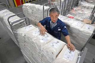 食品スーパー「マルアイ」の物流センターに届いた備蓄米を確認する担当者＝６月３日、加古川市神野町神野