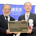 ＩＥＥＥの福田敏男２０２０年会長（左）から、マイルストーン賞の銘板を受け取る篠田傳さん＝１０月、明石市大明石町２