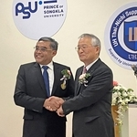 事務所の開設式典で握手するプリンス・オブ・ソンクラー大学のニワット学長（左）と兵庫県立大の高坂誠学長＝プーケット（県立大提供）