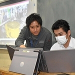 遠隔での溶接を体験する生徒と高丸泰幸専務（左）＝東京都台東区