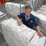 食品スーパー「マルアイ」の物流センターに届いた備蓄米を確認する担当者＝６月３日、加古川市神野町神野