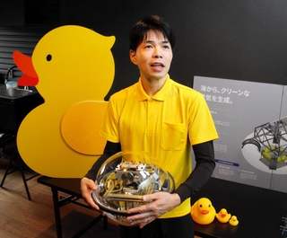 大阪・関西万博に出展した浮体式波力発電の球体型模型を手に、成果を語るイエローダックの中山繁生さん＝加古川市尾上町養田