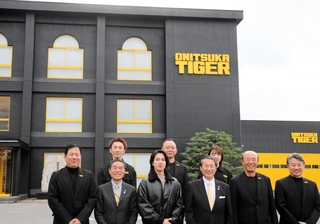 「オニツカイノベーティブファクトリー」の前で記念撮影に臨む山下智久さん（前列左から３人目）ら＝鳥取県境港市渡町