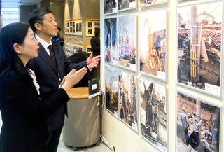 復旧作業の写真に見入るＮＴＴ西日本の西村宜子兵庫支店長（左）と関西電力送配電の松本真也神戸本部長＝神戸市中央区海岸通