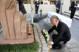 鎮魂碑に献花するコープこうべの馬場一郎理事長＝１７日午前、神戸市東灘区田中町５、コープこうべ生活文化センター