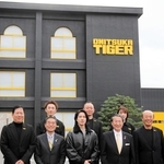 「オニツカイノベーティブファクトリー」の前で記念撮影に臨む山下智久さん（前列左から３人目）ら＝鳥取県境港市渡町