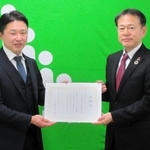 兵庫こども食堂ネットワークの福本大介代表（左）に支援金を贈った生命保険協会兵庫県協会の岡野亮一会長＝神戸市中央区