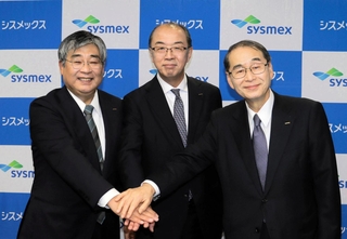 シスメックス次期社長に就く松井石根氏（中央）と浅野薫氏（左）、家次恒氏＝１２日夕、同社本社