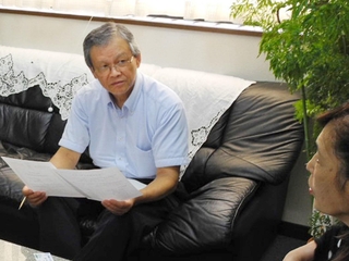 阪神・淡路大震災などの危機を乗り越えた企業に取材する神田栄治さん（左）＝2011年９月、西宮市内