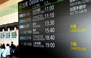 神戸空港第２ターミナルビルの出発案内板。「南京」「上海（浦東）」の欄は「欠航」が表示されている＝２月、神戸市中央区