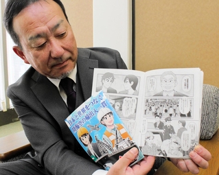 港湾物流の仕事を漫画で分かりやすく紹介した冊子と、作製を担当した大森廻漕店の坊池和彦取締役管理本部長＝神戸市中央区東町