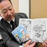 港湾物流の仕事を漫画で分かりやすく紹介した冊子と、作製を担当した大森廻漕店の坊池和彦取締役管理本部長＝神戸市中央区東町