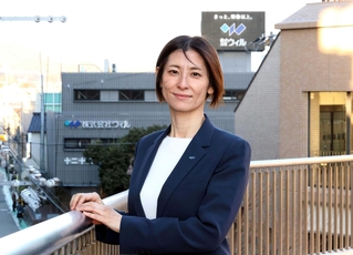 ウィルの社屋を背にする友野泉さん。「社員の人生を輝かせる会社に」と話す＝宝塚市逆瀬川１（撮影・丸山桃奈）