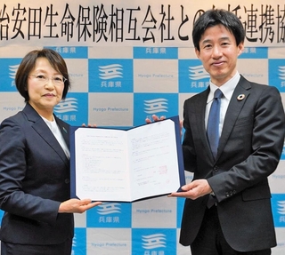協定書を交わす明治安田生命保険の長谷川誓子近畿地域リレーション本部長（左）と兵庫県の守本豊企画部長＝兵庫県庁（兵庫県提供）