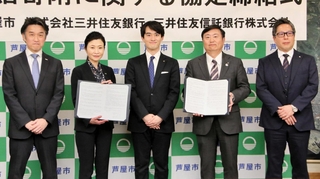 芦屋市の高島崚輔市長（中央）と協定書を交わした三井住友銀行、三井住友信託銀行の役員ら＝同市役所