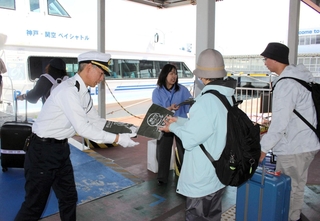 乗客に記念のエコバックが配られた＝神戸空港海上アクセスターミナル