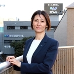 ウィルの社屋を背にする友野泉さん。「社員の人生を輝かせる会社に」と話す＝宝塚市逆瀬川１（撮影・丸山桃奈）