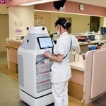 フォーロの胴体部分に検体用の容器を入れ込む看護師＝神戸市中央区楠町７、神戸大病院