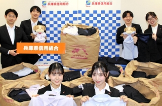 回収した古い制服を持つ兵庫県信用組合の職員ら＝神戸市中央区栄町通３、同信組本店（同信組提供）