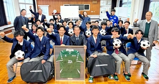 神戸南ロータリークラブが贈った練習用ボールなどを手に、笑顔を見せる飯田高校サッカー部の生徒たち＝４月１７日、石川県珠洲市（同クラブ提供）