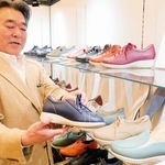 脱ぎ履きしやすい革靴を手にする赤龍化学工業所の高井龍二社長＝神戸市中央区港島中町６