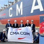 初寄港したコンテナ船の前で記念撮影する関係者ら＝神戸港