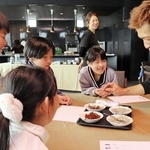 「学童ホテル」の体験会で、淡路市の水産加工会社の社員（右）からイカナゴやちりめんの特徴を教わる児童＝神戸市垂水区海岸通、ホテルセトレ神戸・舞子