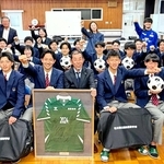 神戸南ロータリークラブが贈った練習用ボールなどを手に、笑顔を見せる飯田高校サッカー部の生徒たち＝４月１７日、石川県珠洲市（同クラブ提供）