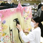 着物にアイロンをかける坂口美紀さんと西田晃三社長＝洲本市中川原町中川原、いせや写真館