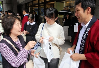 線香のサンプルを受け取った通行人と談笑する「香・未来の会」のメンバー（右）＝神戸市中央区西町