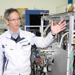 曲面ガラス成形機を前に今後の展開について話す武内製作所の武内隆哲社長＝尼崎市杭瀬本町１
