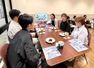 関西学院大神戸三田キャンパスで開かれた交流会で、神鋼鋼線工業の社員（右列奥）と話す学生ら＝三田市学園上ケ原