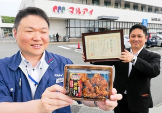 からあげグランプリ中日本スーパー総菜部門で最高金賞を受賞した唐揚げを手にするマルアイの内田滋デリカグループ長（左）と、印南食品の岡井輝雄姫路加工部次長＝加古川市神野町神野