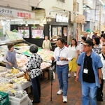 東山商店街を視察する台湾桃園市の商業者ら。手前は神戸市商店街連合会の高四代会長＝神戸市兵庫区東山町１