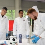 バウムクーヘン作りを体験する岡崎慎司さん（中央）ら＝神戸市中央区港島中町７、ユーハイム本社