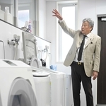 商品の耐久性などを検証するため並べた洗濯機について説明するバリュープランニングの井元憲生社長＝神戸市中央区上筒井通６（撮影・大田将之）