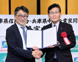協定書を交わした兵庫県中小企業家同友会の藤谷良樹代表理事（左）と兵庫県信用組合の橋爪秀明理事長＝神戸市中央区港島中町６