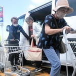 車から降り、店内に入る「買いもん行こカー」の利用者ら＝加古川市東神吉町神吉